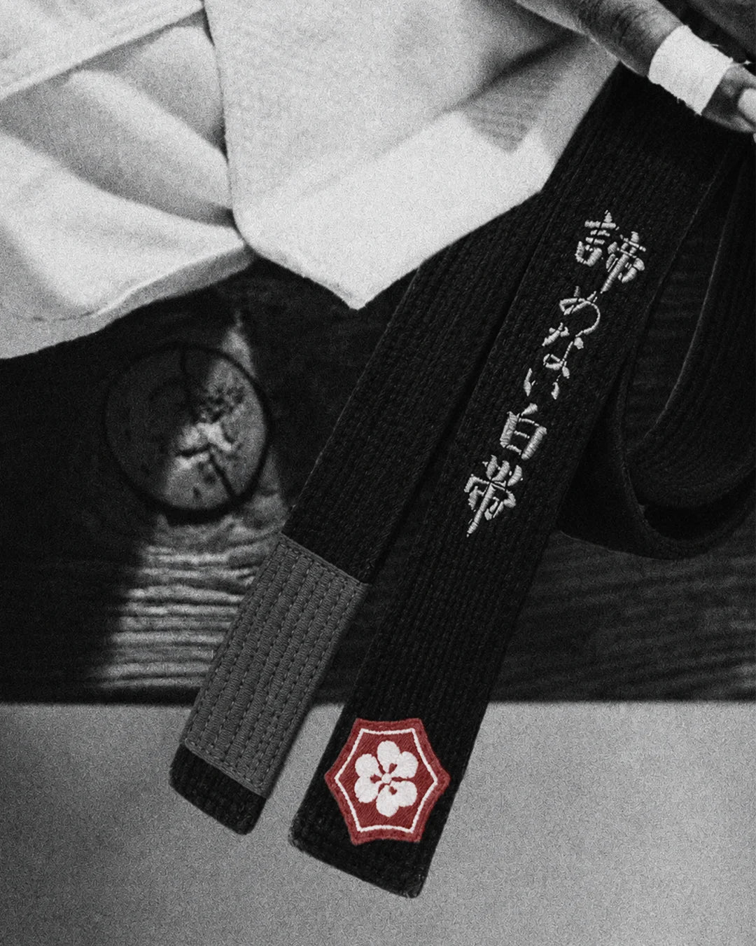 Gold embroidery being stitched onto a black BJJ belt